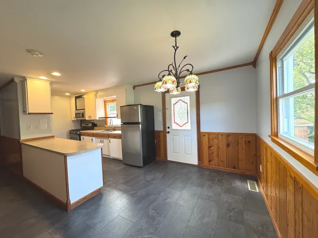 a kitchen with stainless steel appliances granite countertop a refrigerator a stove a sink and a refrigerator