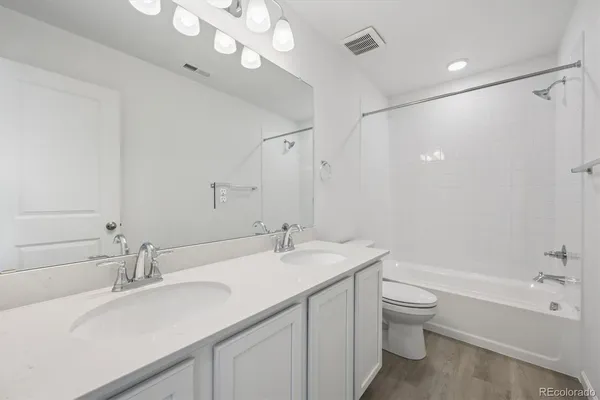 a bathroom with a double vanity sink mirror and toilet