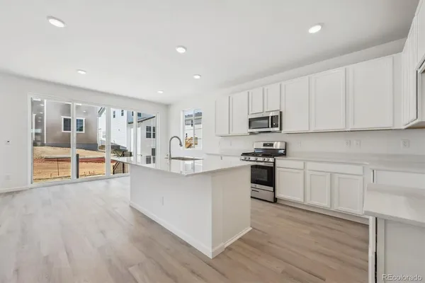 a large kitchen with cabinets and wooden floor