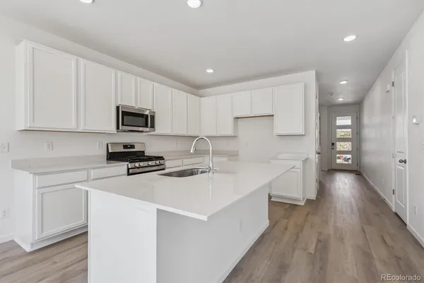 a kitchen with appliances a sink and cabinets