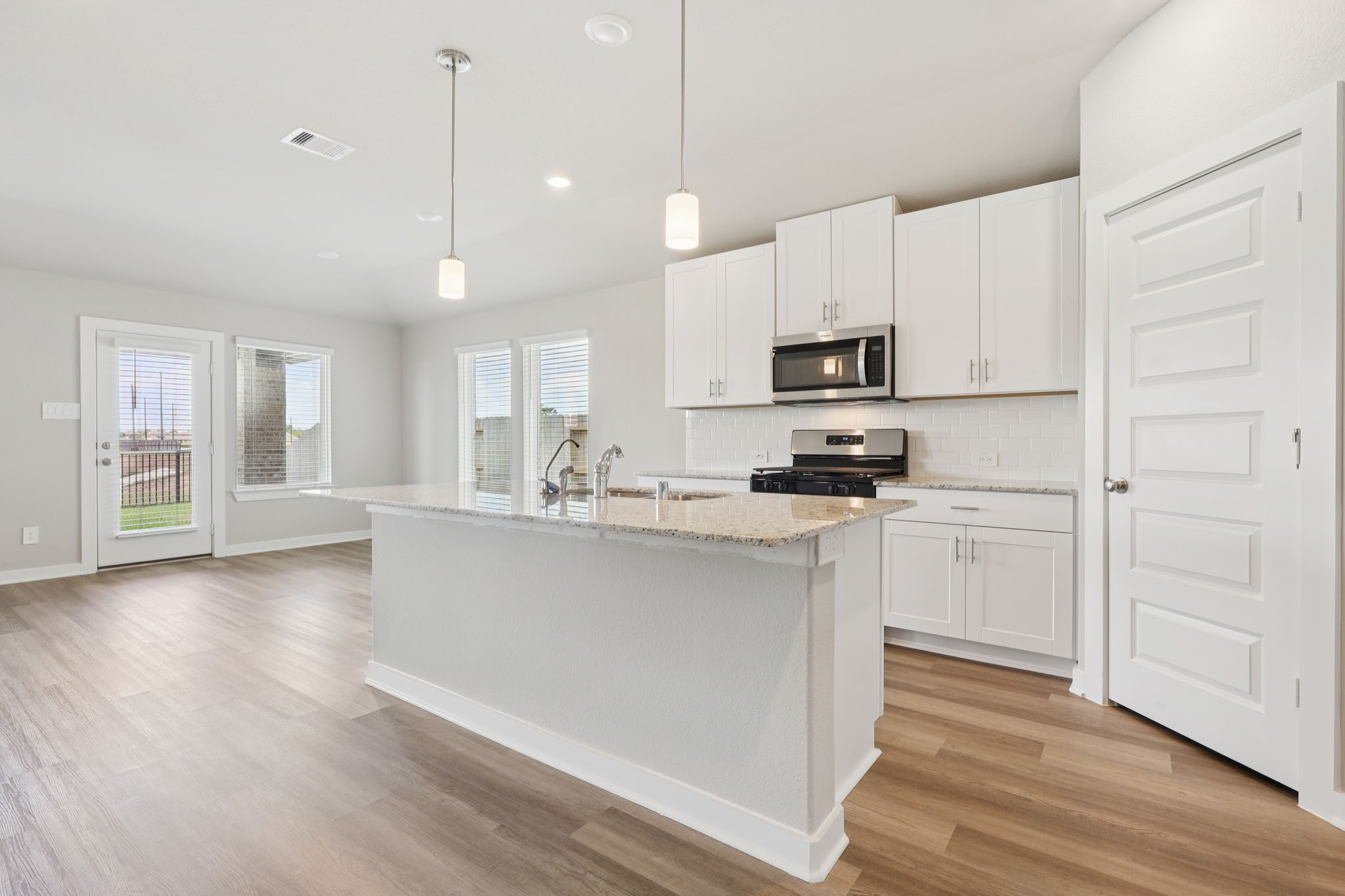 2639 Clapbread Lane Rosenberg, TX 77471 - Photo 12 of 31 a kitchen with kitchen island white cabinets and stainless steel appliances