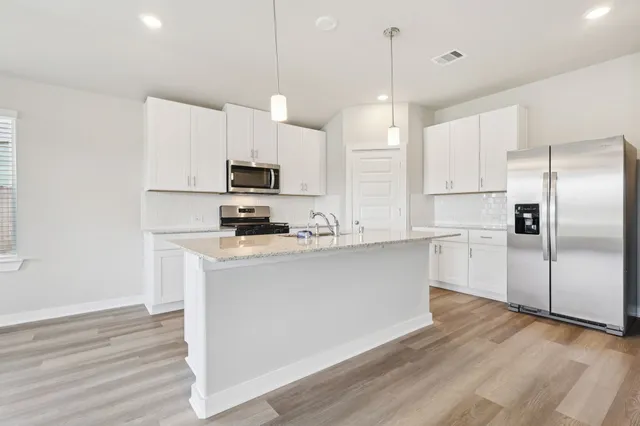 a kitchen with stainless steel appliances a refrigerator sink and microwave