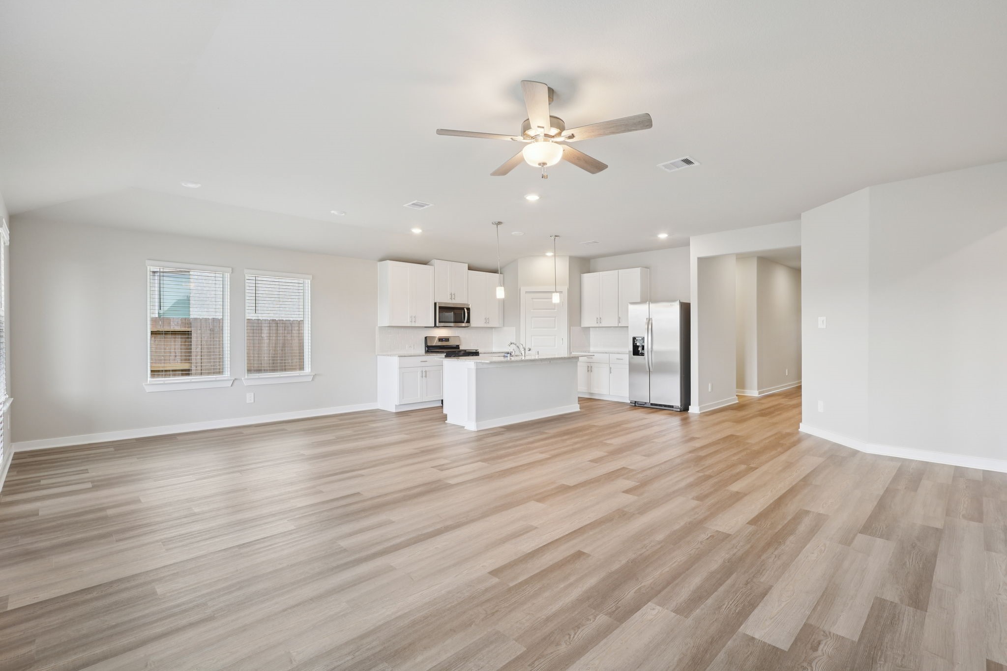 2639 Clapbread Lane Rosenberg, TX 77471 - Photo 8 of 31 a view of an empty room with wooden floor and a kitchen