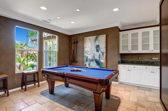 a room with pool table and windows