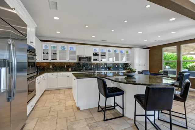a kitchen with stainless steel appliances kitchen island granite countertop a sink and cabinets