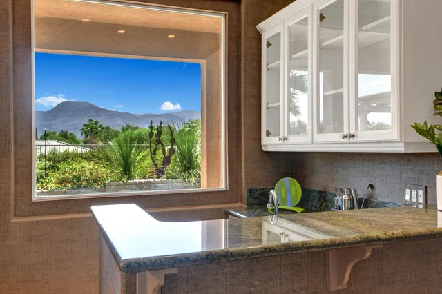 a bathroom with a granite countertop sink and a window