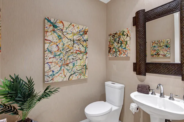 a bathroom with a toilet sink and mirror