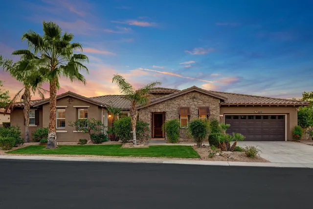 front view of house with a yard and palm trees