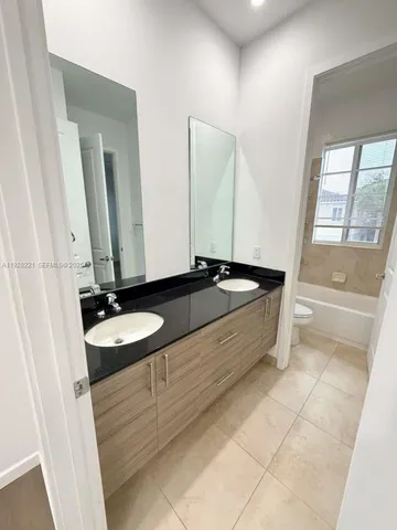 a bathroom with a double vanity sink and a mirror