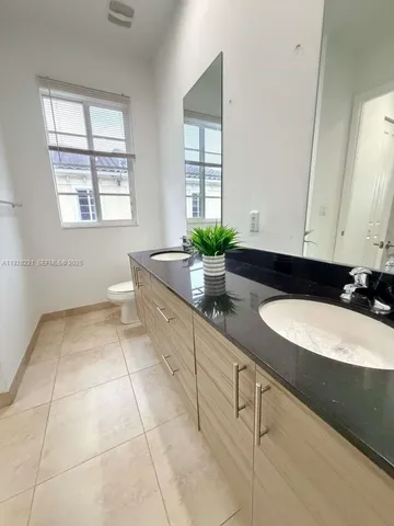 a bathroom with a granite countertop sink a mirror and a window