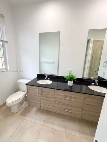 a bathroom with a toilet a sink and mirror