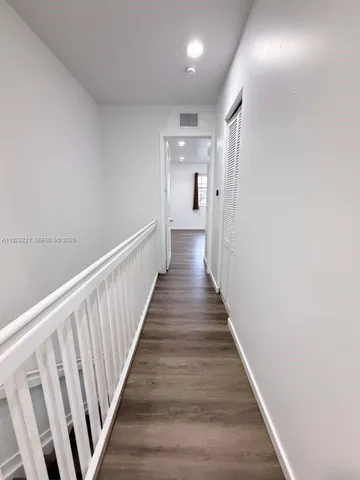 a view of a hallway with wooden floor