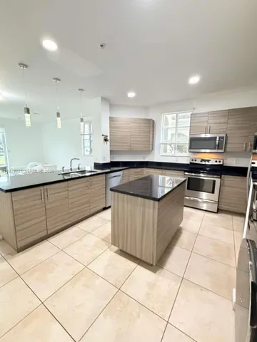 a large kitchen with a large counter top and kitchen view