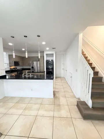 a view of kitchen with stainless steel appliances kitchen island granite countertop a large stove top oven and a refrigerator