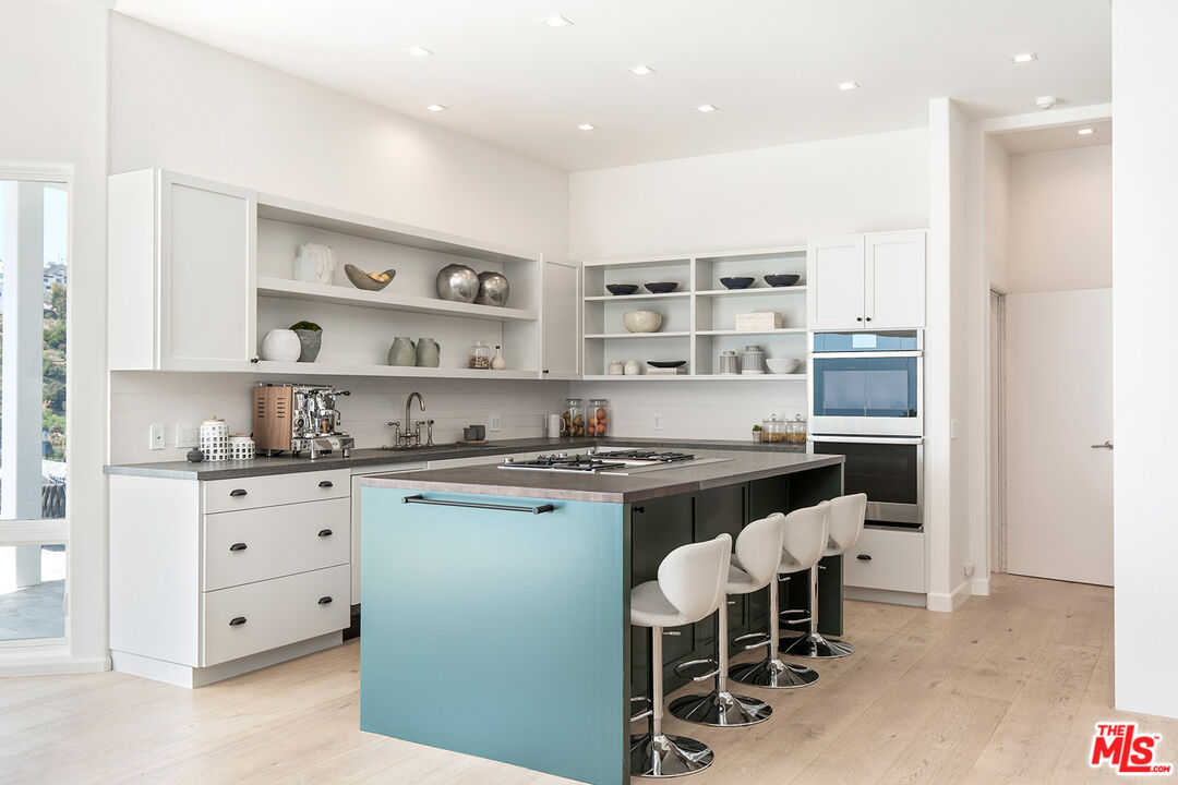 7868 Electra Drive Los Angeles, CA 90046 - Photo 22 of 38 a kitchen with stainless steel appliances granite countertop a stove and a refrigerator