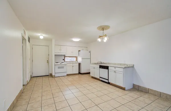 a kitchen with white cabinets and white appliances