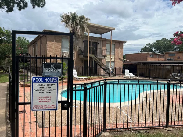 a view of a brick house with a small yard