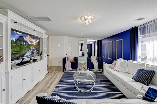 a living room with furniture a flat screen tv and a window