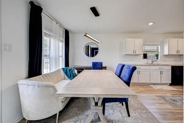 a living room with furniture a flat screen tv and kitchen view