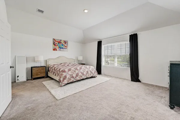 a bedroom with a bed and a large window