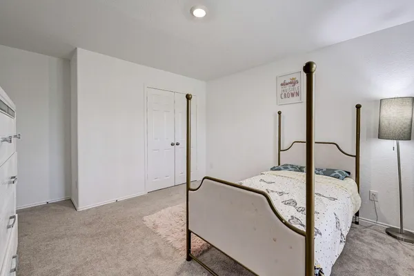 a bed sitting in a bedroom next to a lamp