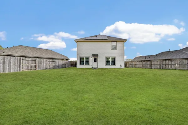 a view of an house with backyard space and balcony