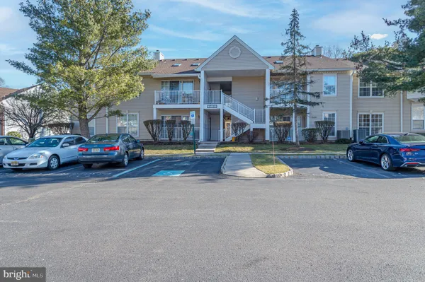 a view of a building with cars park in front of house