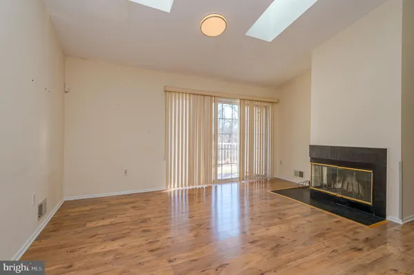 a view of an empty room with a fireplace and a window