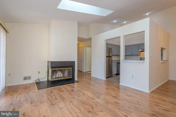 a view of empty room with a fireplace and wooden floor