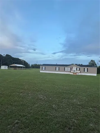 a view of a field with an trees in the background