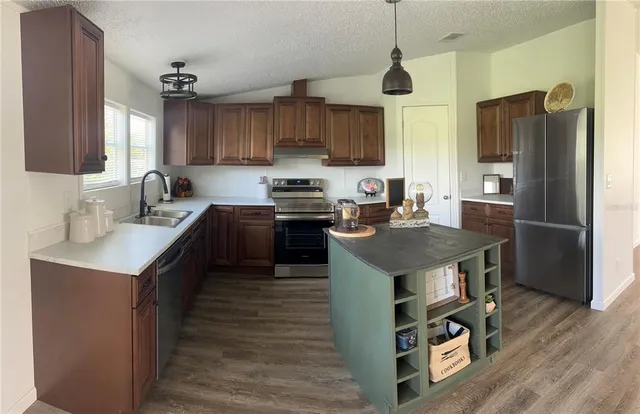a kitchen with stainless steel appliances granite countertop a stove a sink and a refrigerator