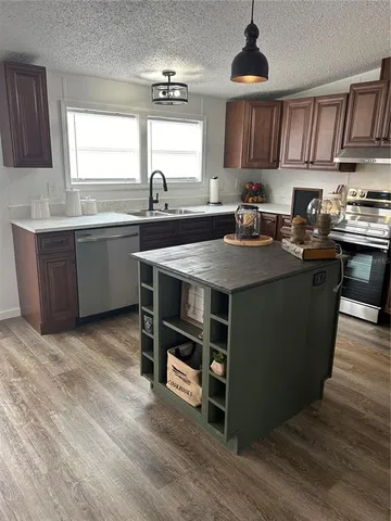 a kitchen with stainless steel appliances wooden cabinets a center island and a refrigerator