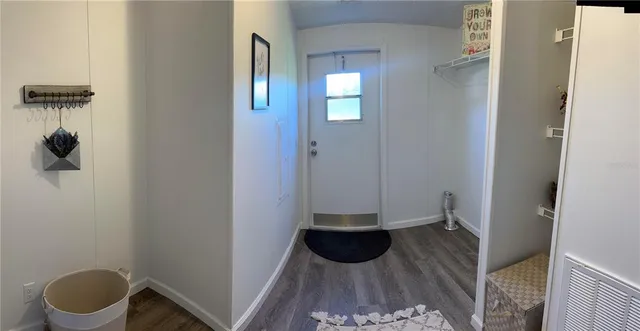 a view of a hallway with a livingroom and a bathroom with a sink