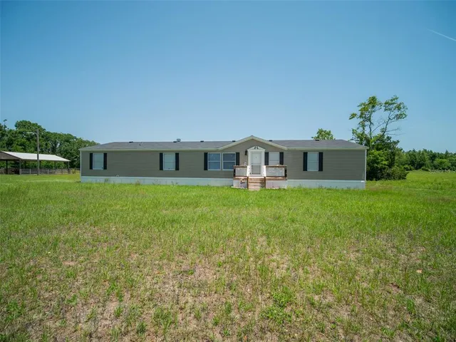 a view of a house with backyard and porch