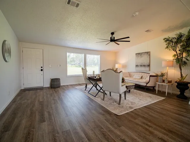 a view of a dining room with furniture a chandelier and wooden floor