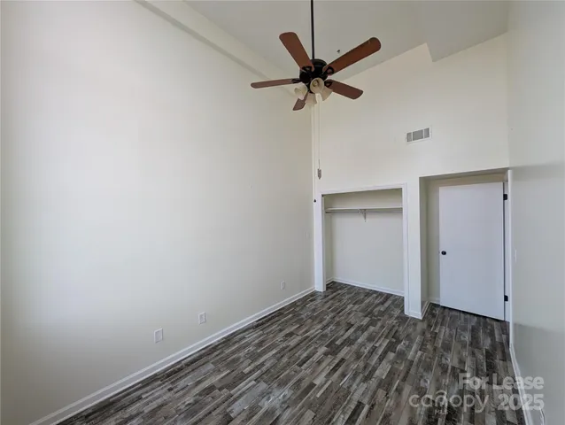 a view of a room with a ceiling fan and wooden floor