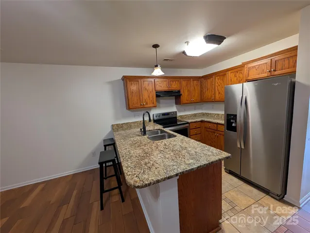 a kitchen with stainless steel appliances granite countertop a refrigerator and a sink