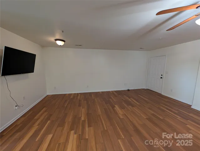 a view of a room with wooden floor and flat screen tv