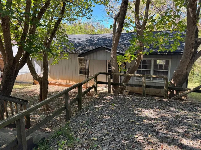 a small barn with a big yard and large trees