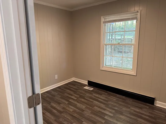 a view of a room with wooden floor and window