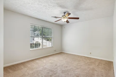 an empty room with a window and a fan