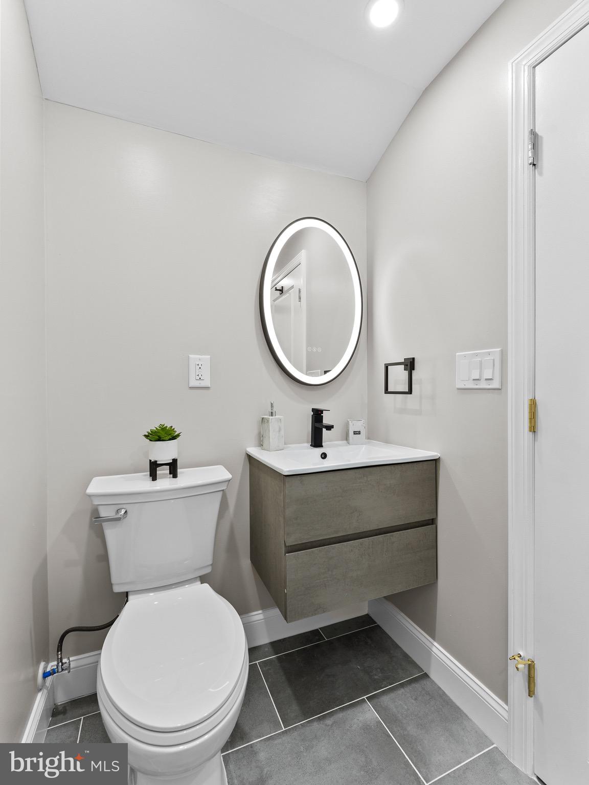1202 Woodruff Road Glassboro, NJ 08028 - Photo 15 of 28 a bathroom with a toilet a sink and a mirror
