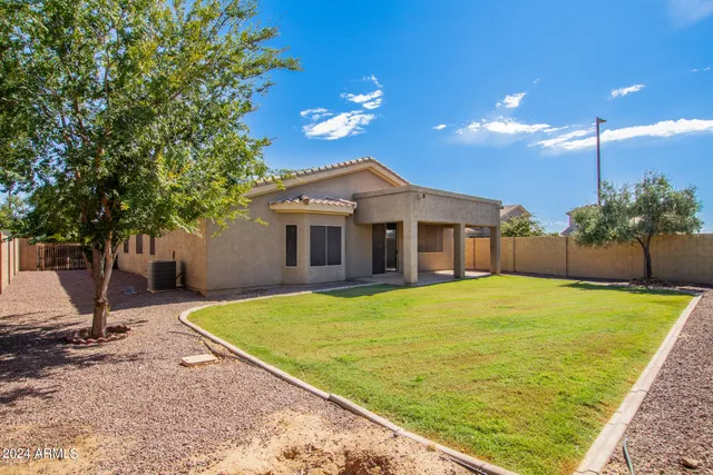 a view of a house with backyard and tree