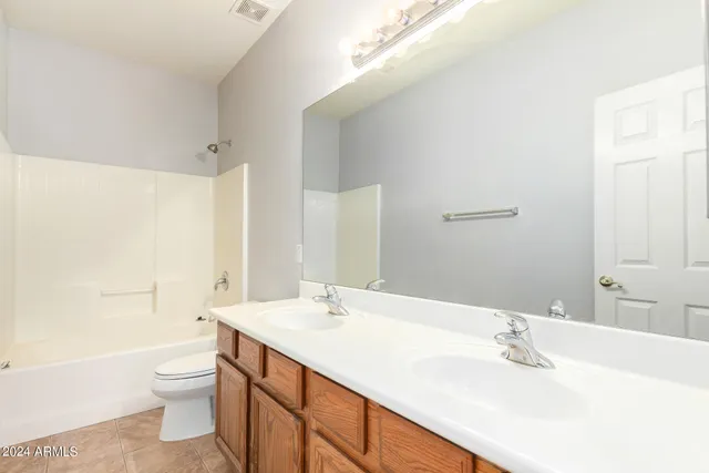 a bathroom with a double vanity sink toilet and a bathtub
