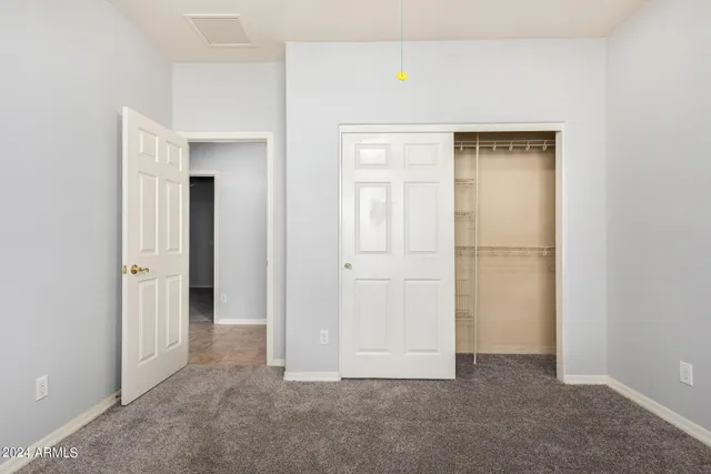 an empty room with windows and closet