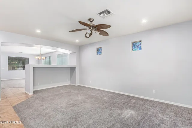 an empty room with windows and fan