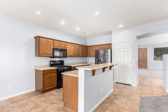 a kitchen with stainless steel appliances a stove top oven a sink a counter top space and cabinets