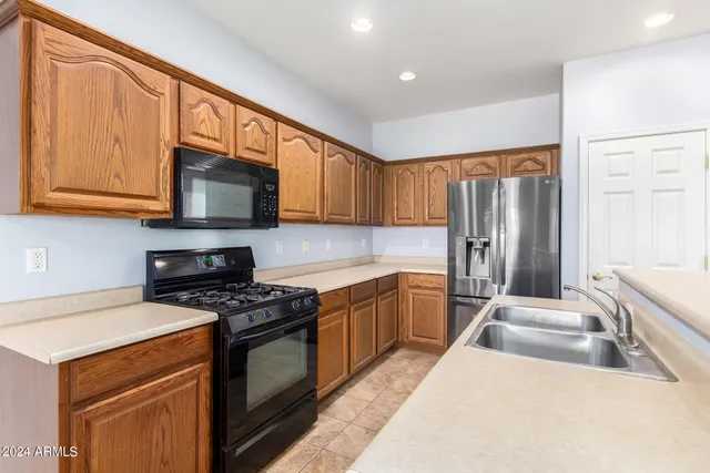 a kitchen with stainless steel appliances a stove sink microwave and refrigerator