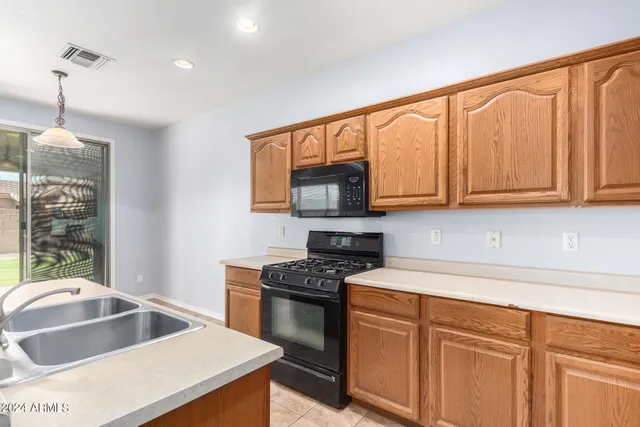 a kitchen with granite countertop a sink a stove and cabinets