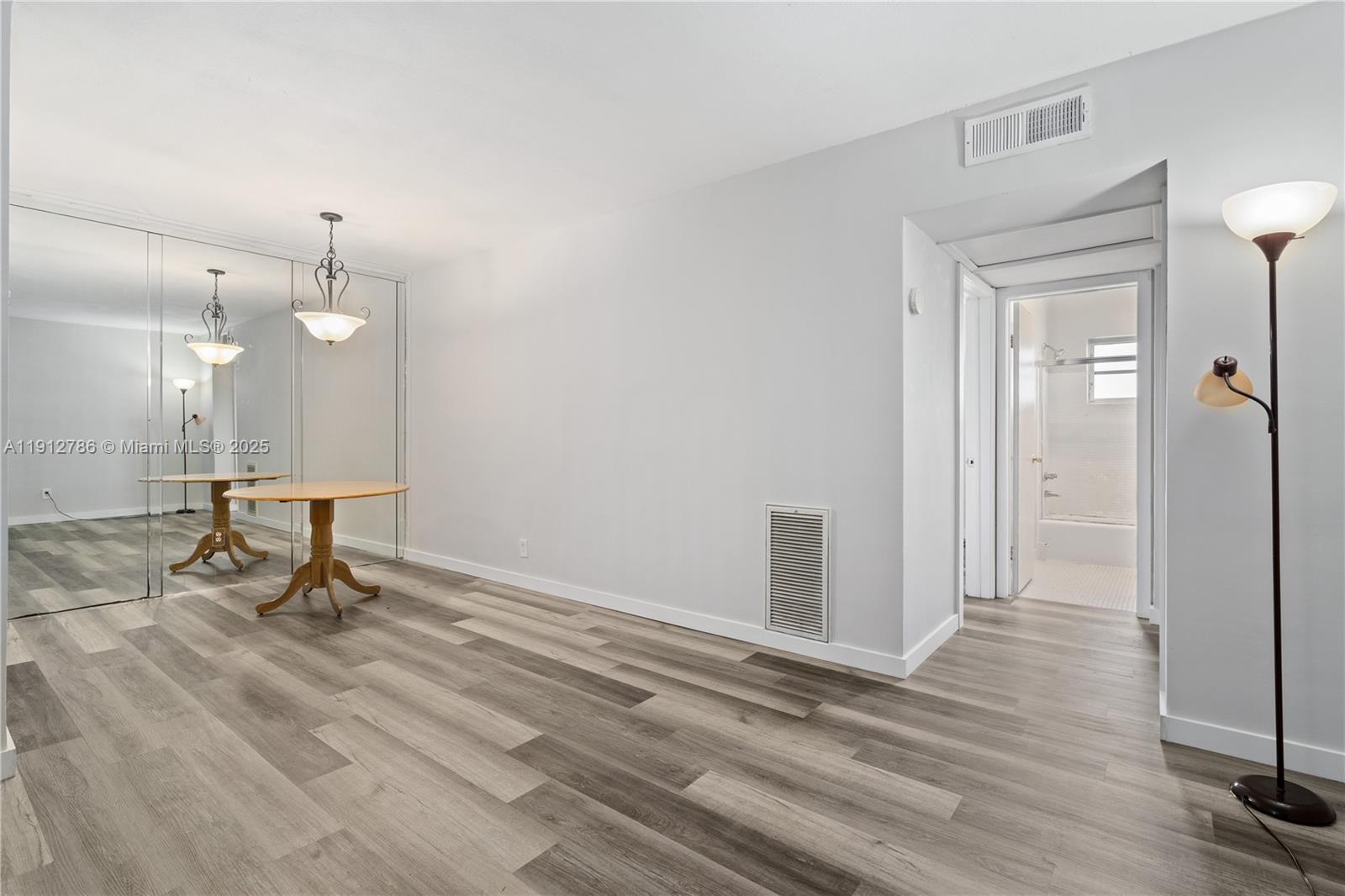1420 Atlantic Shores Boulevard, Unit 340 Hallandale Beach, FL 33009 - Photo 4 of 33 a view of a room with wooden floor and glass door